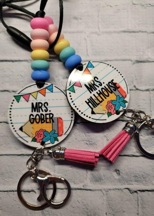 Handmade personalized teacher keychains with colorful beads, tassels, and floral accents