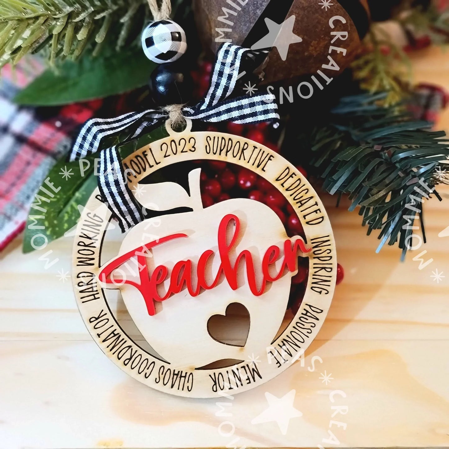 Handmade wood teacher ornament with red script, plaid ribbon, and greenery accents