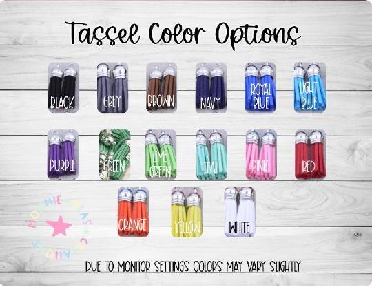 Tassel color options showing black, grey, brown, navy, royal blue, light blue, purple, green, lime green, teal, pink, red, orange, yellow, white on wooden background