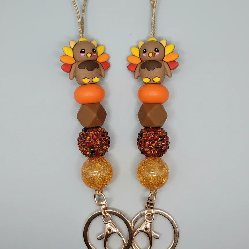 Handmade turkey-themed lanyards with yellow, orange, and brown beads, festive fall gift