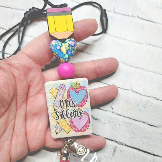 Handmade colorful teacher badge reel with pencil charm, heart bead, and custom name tag