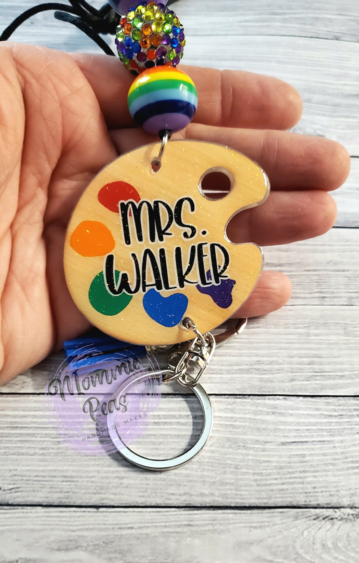 Handmade colorful artist palette keychain gift with rainbow beads and personalized name, held in hand