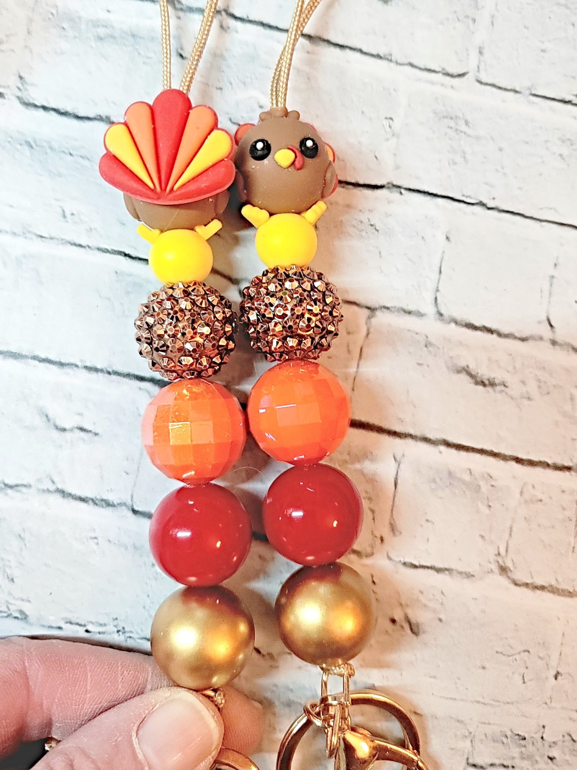 a pair of colorful beaded keychains with a bird-shaped charm on each.