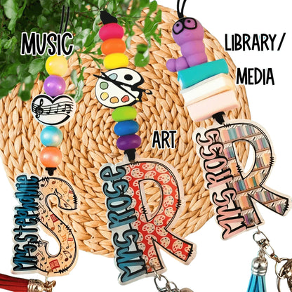 Colorful handmade teacher gifts with custom beads and charms for music, art, library themes.