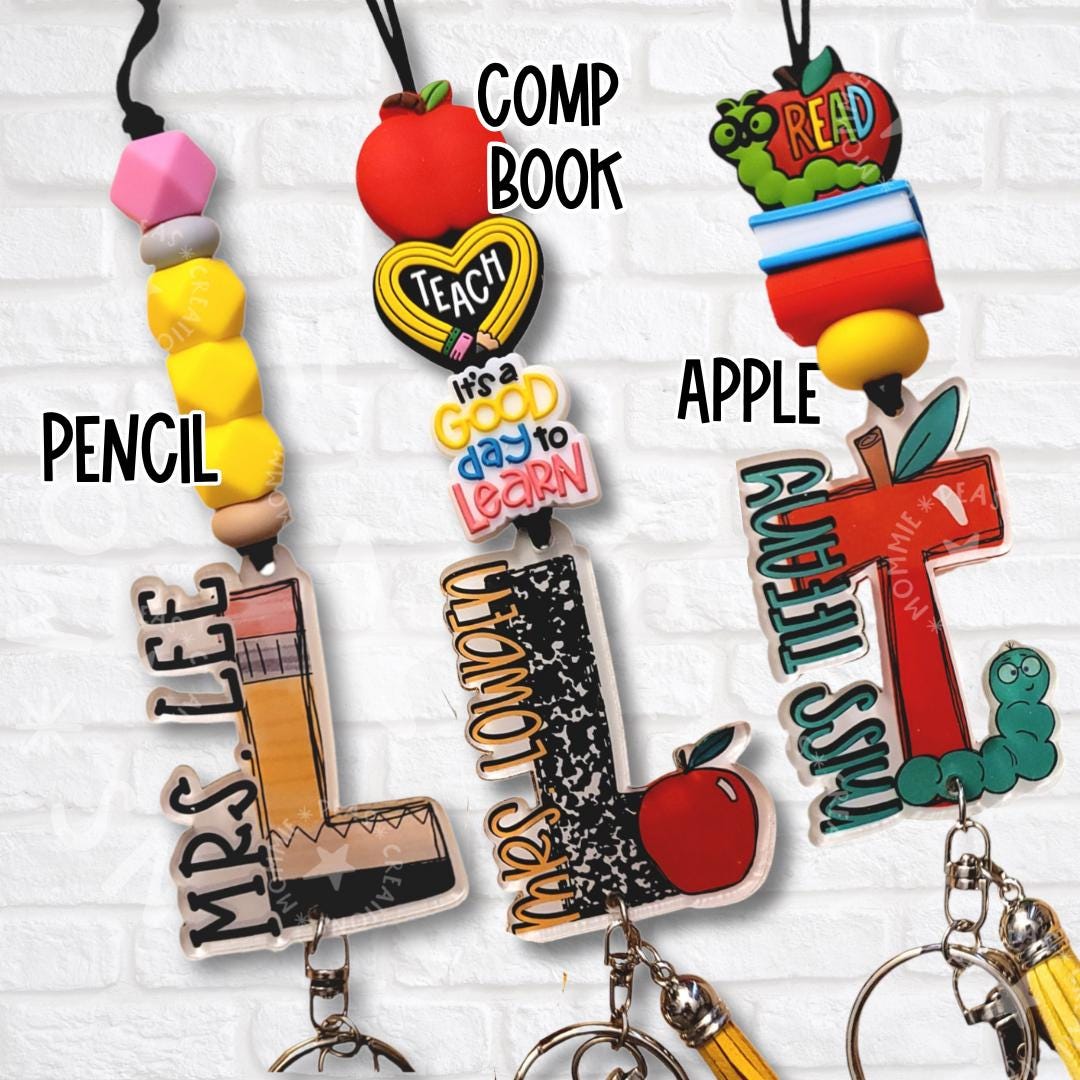 Three teacher lanyards with pencil, composition notebook, and apple bead toppers attached to custom acrylic initial charms for Mrs. Lee, Mrs. London, and Miss Tiffany.