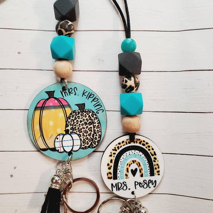 Personalized keychains with leopard print accents and colorful beads on white wood background