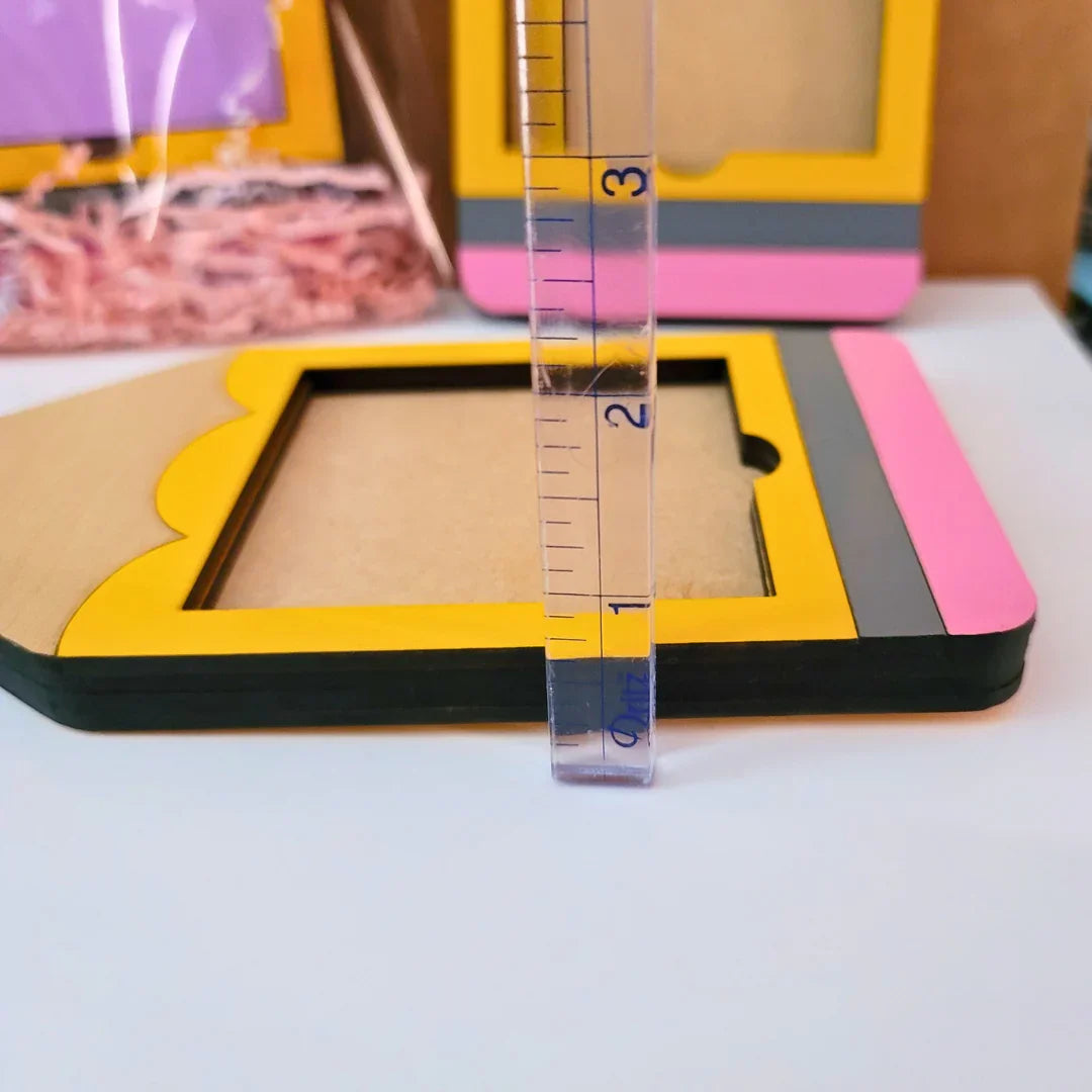 Handmade yellow, pink, and gray pencil-shaped gift frame with ruler for size reference