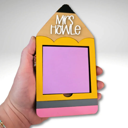 Hand holding a handmade yellow pencil-shaped notepad holder with pink and grey accents, personalized teacher gift