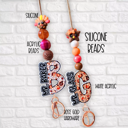 Keychains with silicone turkey and star beads, acrylic number charms, rose gold hardware on white brick background