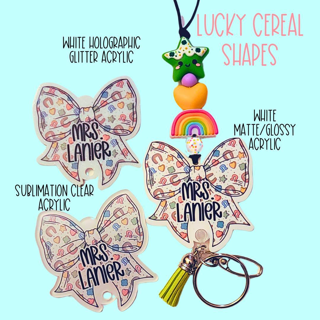 Three Mrs Lanier bow keychains with white holographic, sublimation, and matte/glossy acrylic on blue background