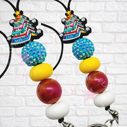Handmade lanyard with colorful Christmas tree charm, blue glitter bead, yellow, red, and white beads
