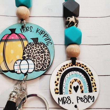 Personalized fall keychains with pumpkins and leopard print rainbows, decorated with wooden and turquoise beads