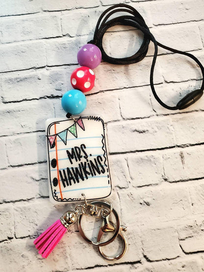 Lanyard keychain with colorful beads and a white tag reading Mrs. Hawkins, pink tassel accessory