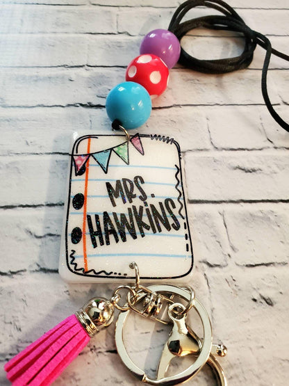 Colorful beaded keychain with notebook paper charm reading Mrs. Hawkins and pink tassel