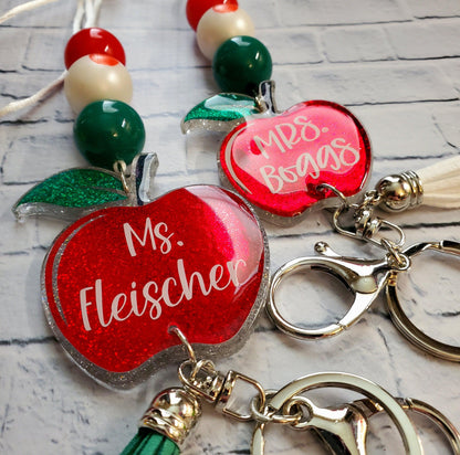 Custom red apple keychains with names Ms. Fleischer and Mrs. Boggs on beaded lanyards