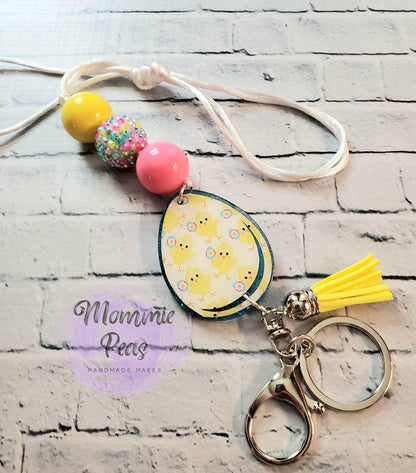 Easter-themed keychain with yellow chick egg charm, pink and yellow beads, yellow tassel on white cord