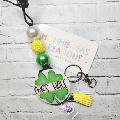 Personalized badge reel with green four-leaf clover, beads, yellow tassel, and keychain clip