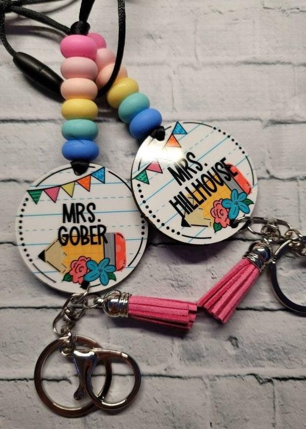 Colorful personalized keychains with names Mrs. Gober and Mrs. Hillhouse, decorated with pastel beads, tassels, and floral designs
