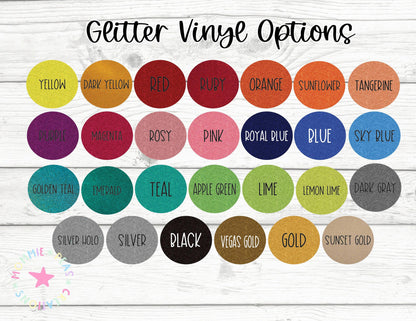 Glitter vinyl options chart showing 28 colors including yellow, red, royal blue, teal, black, gold, and silver on white wood background