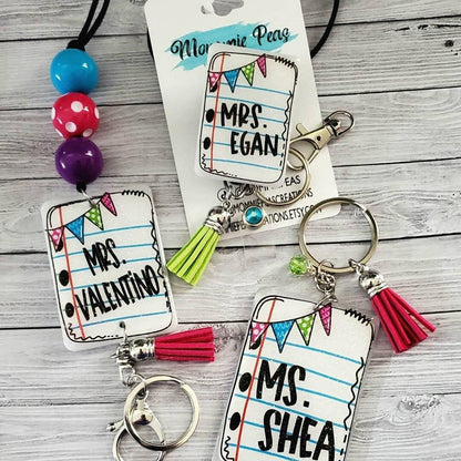 Personalized teacher keychains with names Mrs. Valentino, Mrs. Egan, Ms. Shea on notebook paper design with colorful tassels