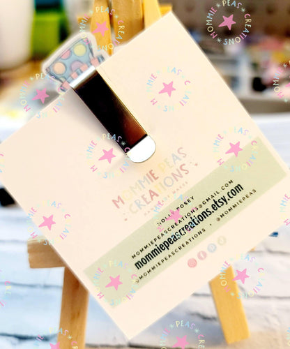 Colorful polka dot earrings displayed on a branded Mommie Peas Creations card with contact info