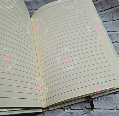 Open blank lined journal with cream pages on gray brick background