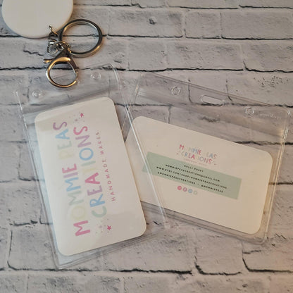 Mommie Peas Creations handmade cards in clear badge holders on a brick background with a metal keychain clip