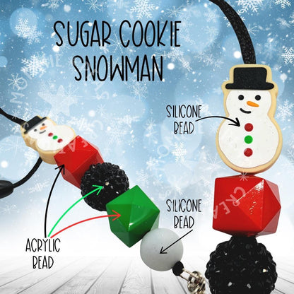 Sugar cookie snowman pendant necklace with acrylic and silicone beads against snowy background