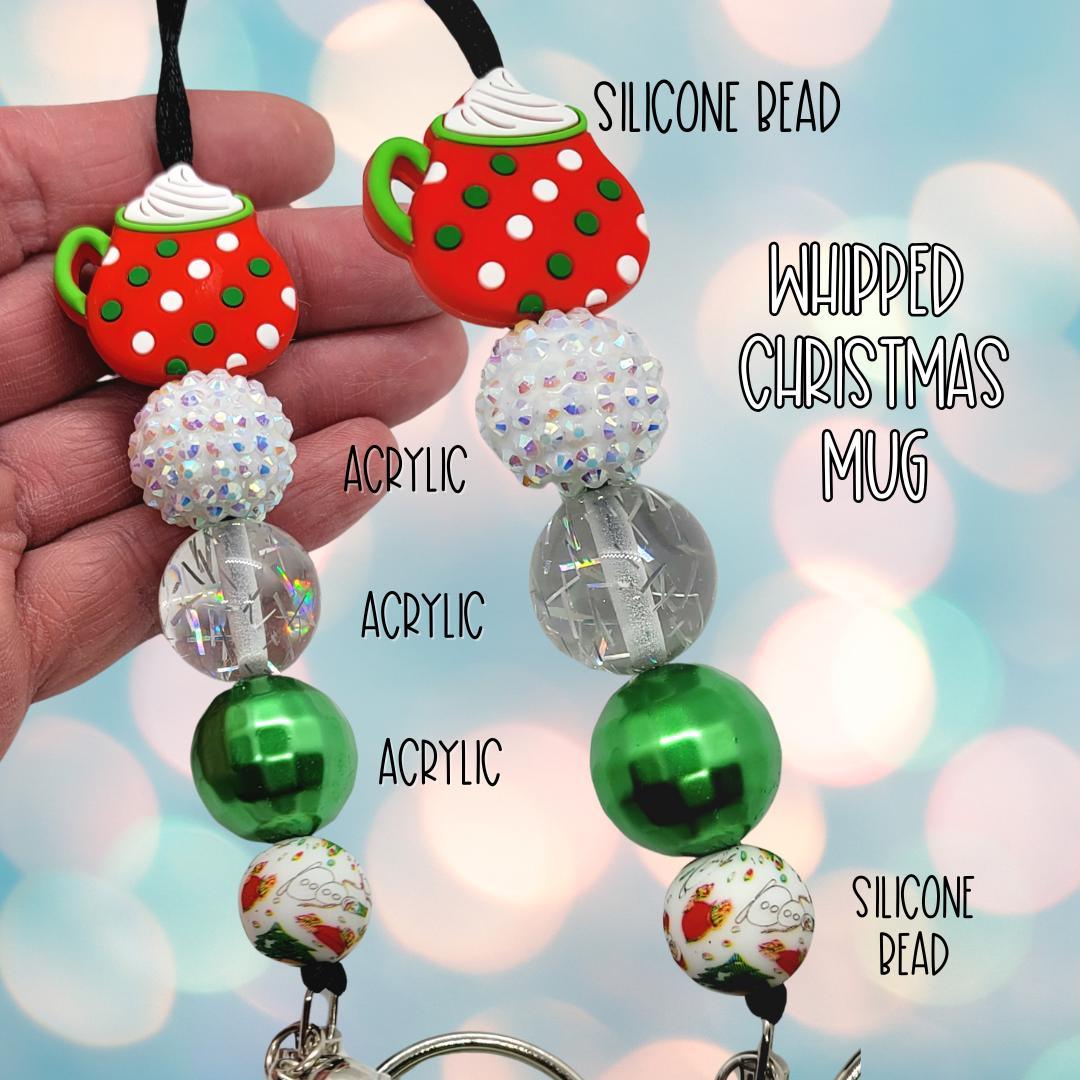 Hand holding Christmas-themed keychain with red polka dot mug silicone bead and assorted acrylic beads