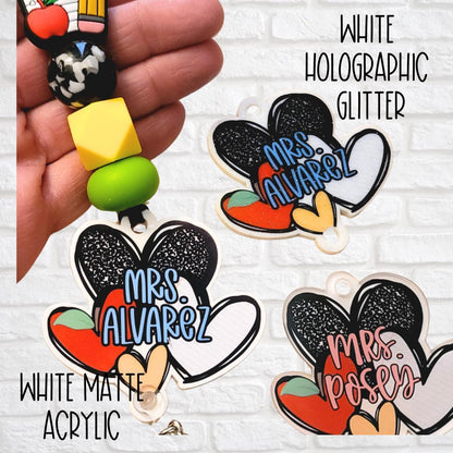 Hand holding colorful beaded keychain with black and white acrylic Minnie Mouse charm featuring names Mrs. Alvarez and Mrs. Posey