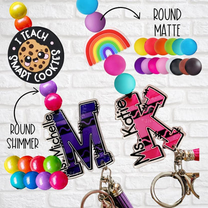 Colorful custom teacher keychains with names, round shimmer and matte beads, and cookie and rainbow charms
