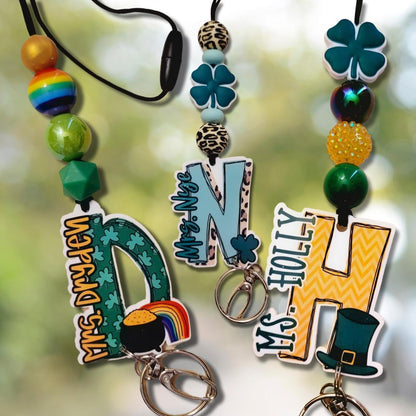 Three personalized St. Patrick's Day keychains with colorful beads, shamrocks, rainbows, and leprechaun hat charms