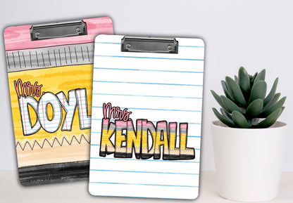 Two personalized clipboards with names Mrs. Doyl and Mrs. Kendall alongside a green succulent plant