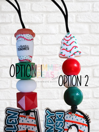 Two holiday-themed teacher lanyard options with festive beads and Christmas designs against white brick wall