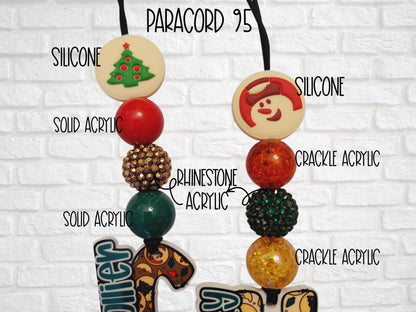 a necklace with various Christmas-themed ornaments, including a Christmas tree, a snowman, and other festive decorations.