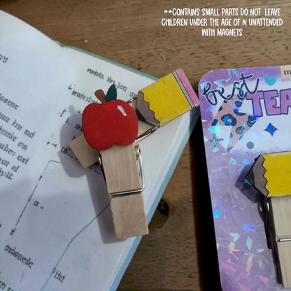 Mommie Peas Creations hand-painted wooden clothespins with apple and pencil designs, featuring strong magnets.