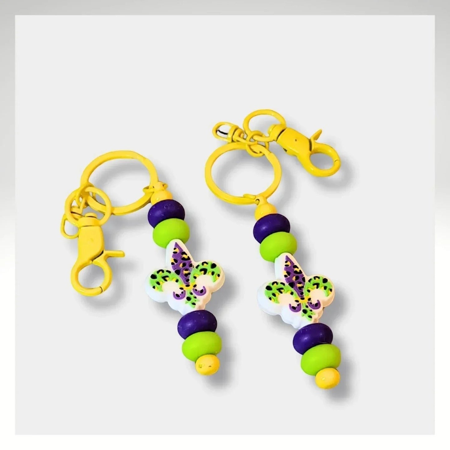 Mommie Peas Creations Mardi Gras keychain with purple, green, and yellow beads and a fleur-de-lis charm.