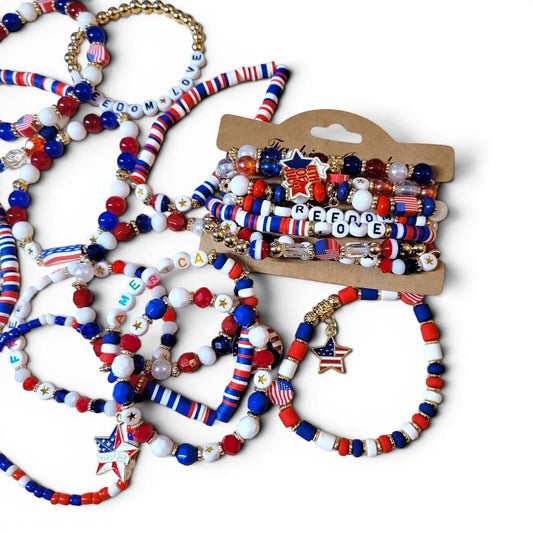 Mommie Peas Creations patriotic beaded bracelets with red, white, blue vinyl discs, USA/2026 letter beads, and gold star charms.
