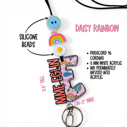 Handmade rainbow-themed lanyard with silicone beads, daisy, and globe charm, crafted by Mommie Peas Creations.