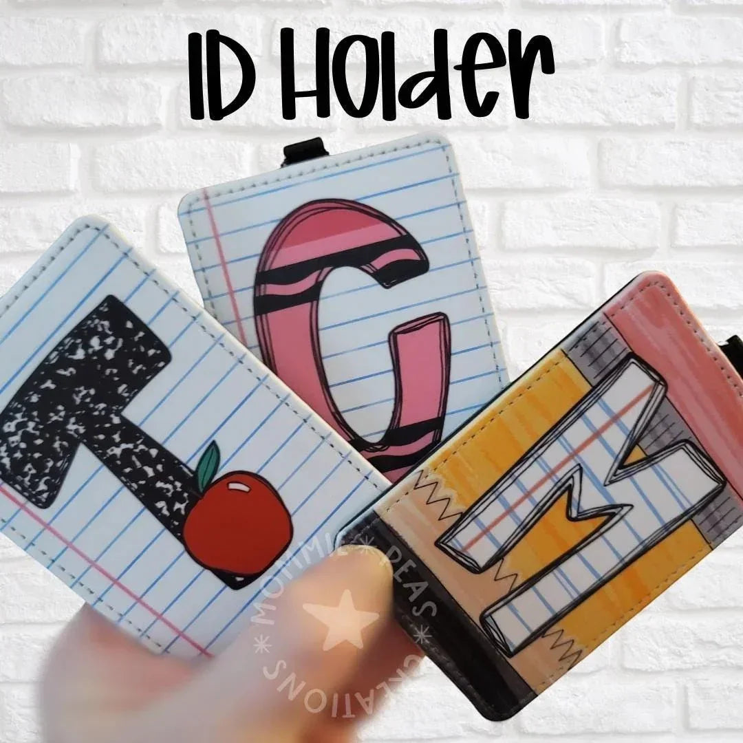 Mommie Peas Creations vertical ID badge holders featuring school-themed designs like letters, an apple, and crayon art on a notebook paper background.