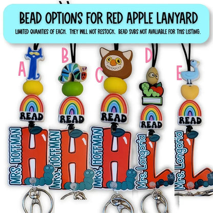 Mommie Peas Creations personalized teacher lanyard with rainbow, READ charm, and custom name. Options include The Cat in the Hat, The Very Hungry Caterpillar, Owl, and The Very Busy Spider.