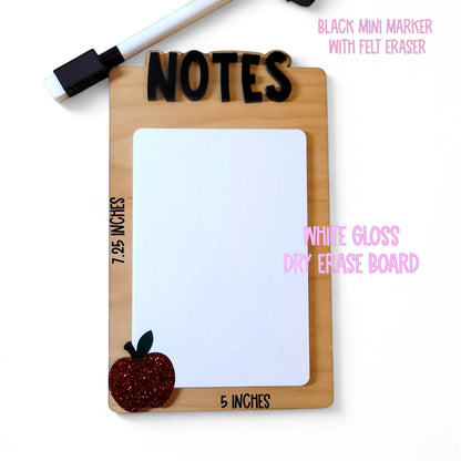Mommie Peas Creations wooden teacher notes board with white dry erase surface, black 3D 'NOTES' text, and a red glitter apple accent.