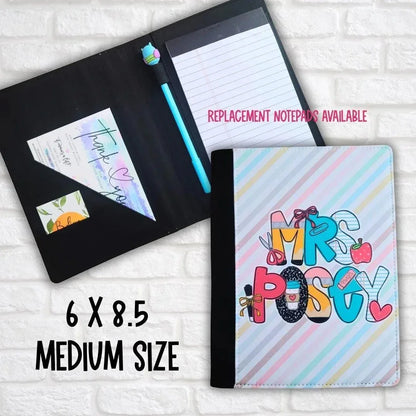 Mommie Peas Creations personalized teacher padfolio, medium size (6x8.5), with a pastel striped cover featuring "Mrs. Posty" in colorful block letters with school-themed icons.