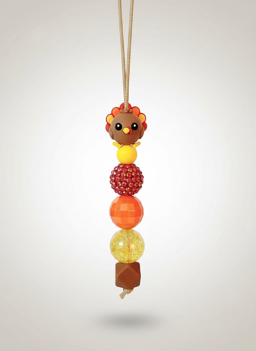 Mommie Peas Creations Thanksgiving Turkey beaded lanyard with red, orange, and yellow beads and a 3D turkey charm.