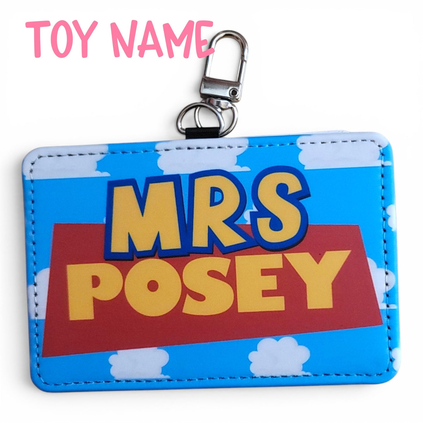 Mommie Peas Creations personalized ID holder with Toy Story inspired cloudy sky background and yellow name text.