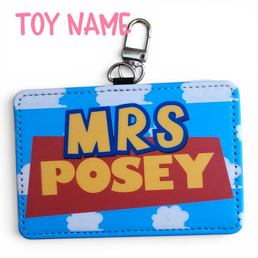 Mommie Peas Creations personalized ID holder with Toy Story inspired cloudy sky background and yellow name text.