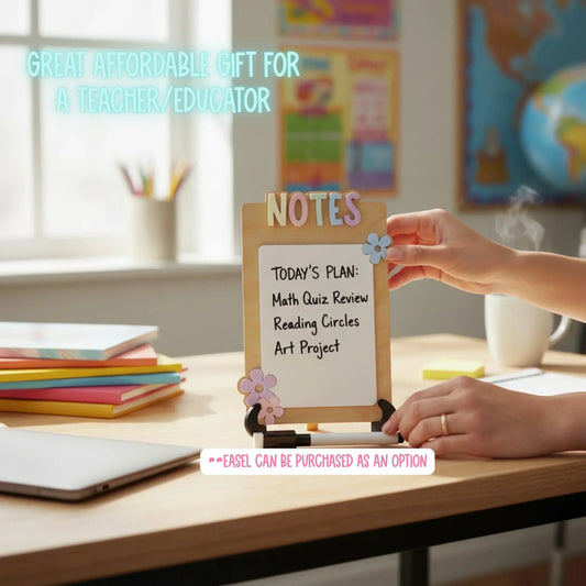 Mommie Peas Creations handmade dry erase notes board with pastel flower accents and 'NOTES' lettering. A hand is adding a flower accent.
