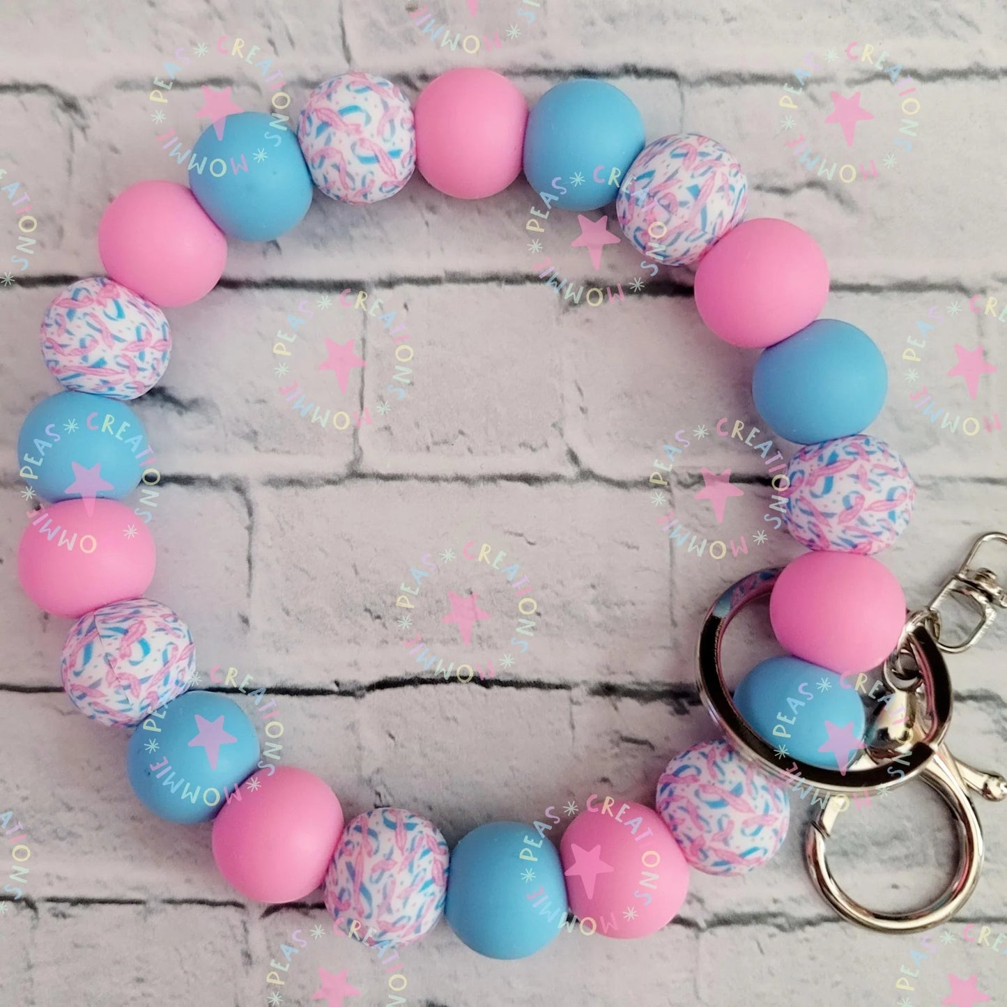 Mommie Peas Creations pink and blue silicone beaded wristlet keychain with infant loss awareness ribbon pattern and star details.