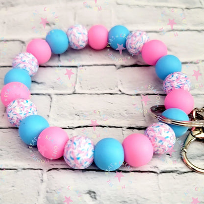 Mommie Peas Creations infant loss awareness wristlet keychain with pink, blue, and patterned silicone beads.