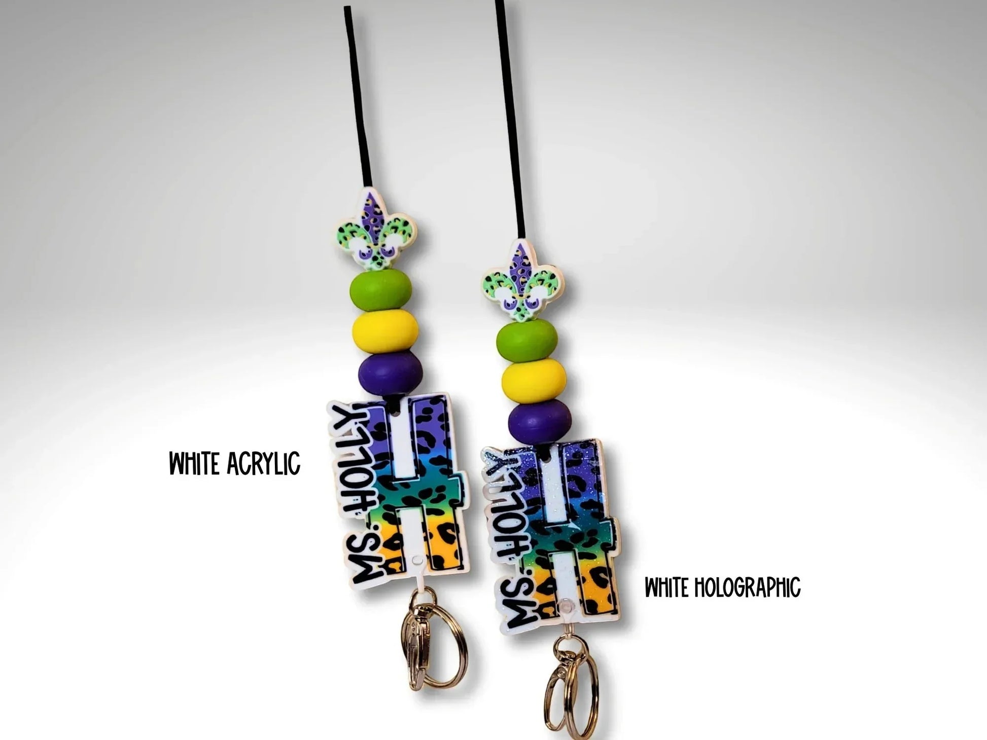 Mardi Gras initial lanyard by Mommie Peas Creations with purple, green, and gold beads and a custom acrylic initial charm. Available in white acrylic and white holographic.